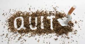 Tobacco and cigarette forming the word 'QUIT' on a white background