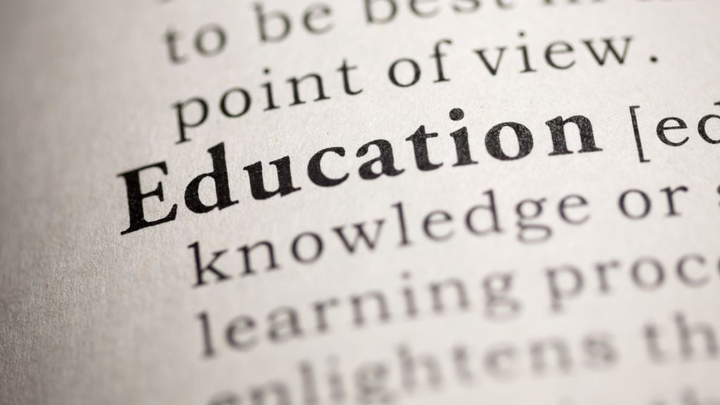 The word "Education" in focus on a printed page, emphasizing the importance of knowledge and learning.